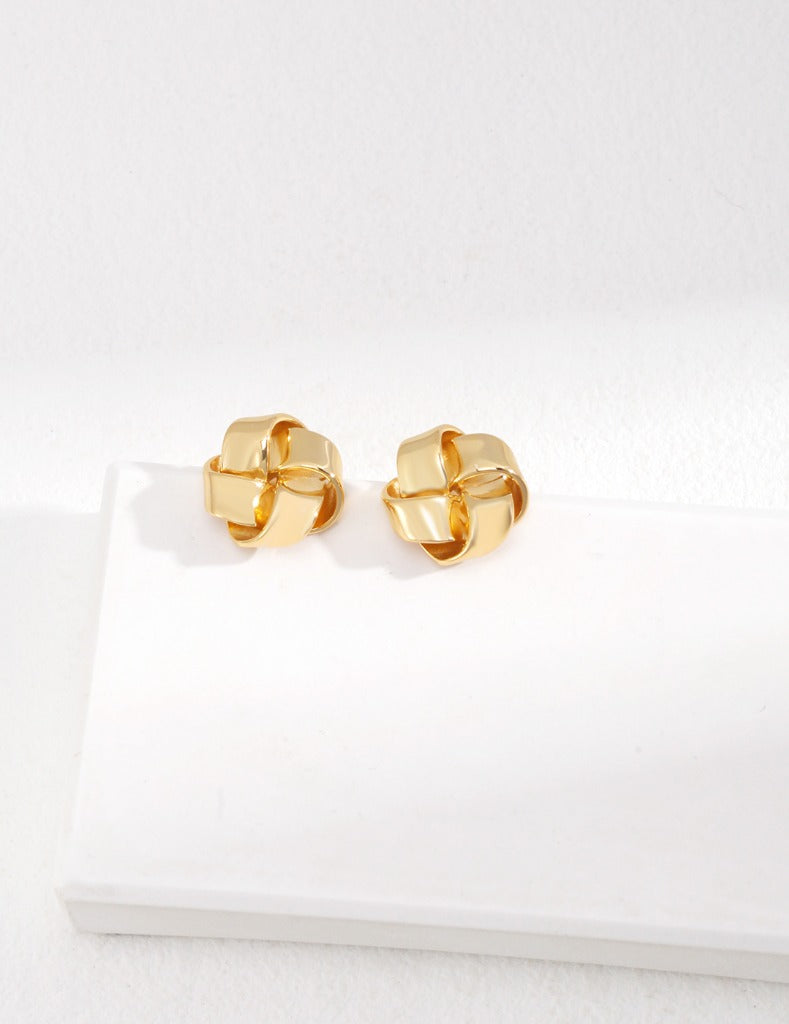 The shining golden knot-shaped earrings are simple and fashionable, exuding charming charm when worn on the ears.